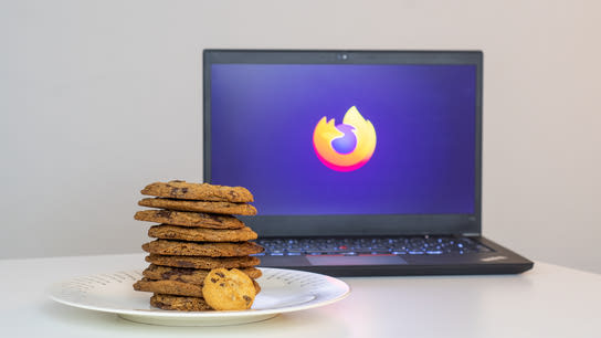 A plate with a tall stack of cookies. A laptop with the Firefox logo sits in the background.